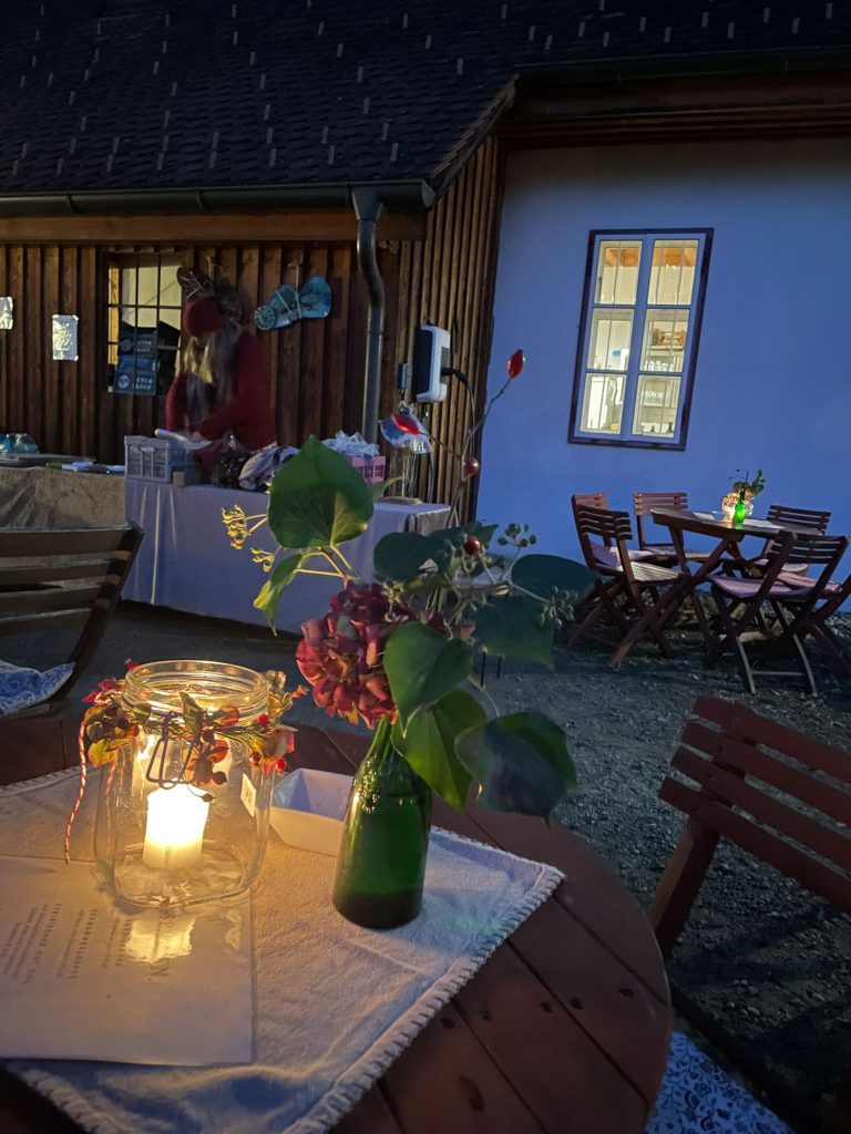 Brennende Kerze in Glas auf einem Holztisch im Freien