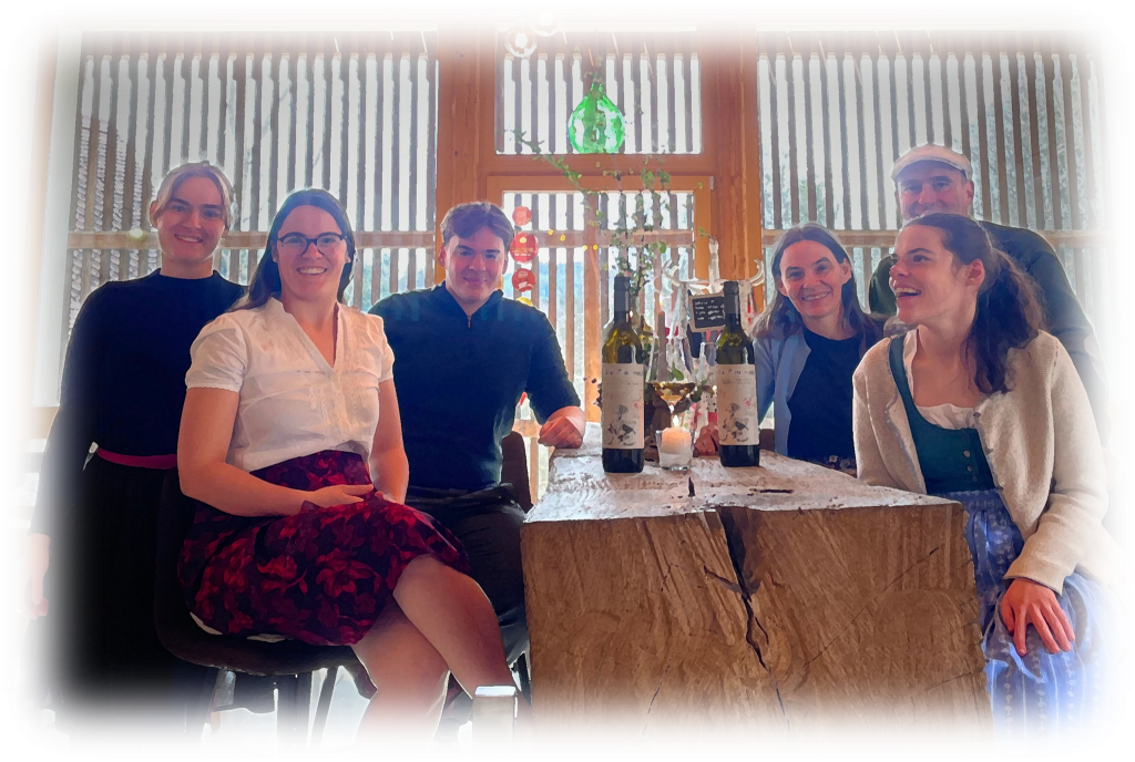 Familie Skoff sitzt im Genussladen neben einem alten Pressbaum