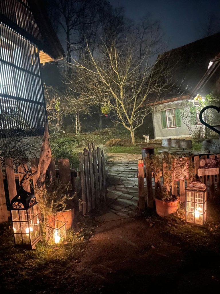 Stimmungsvoll beleuchteter Garten im Winter mit Kerzenschein