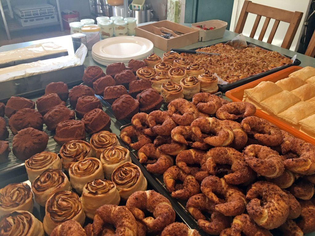 Eine Auswahl an Backwaren im Hofcafé, darunter Plunder, Croissants und Apfeldesserts.