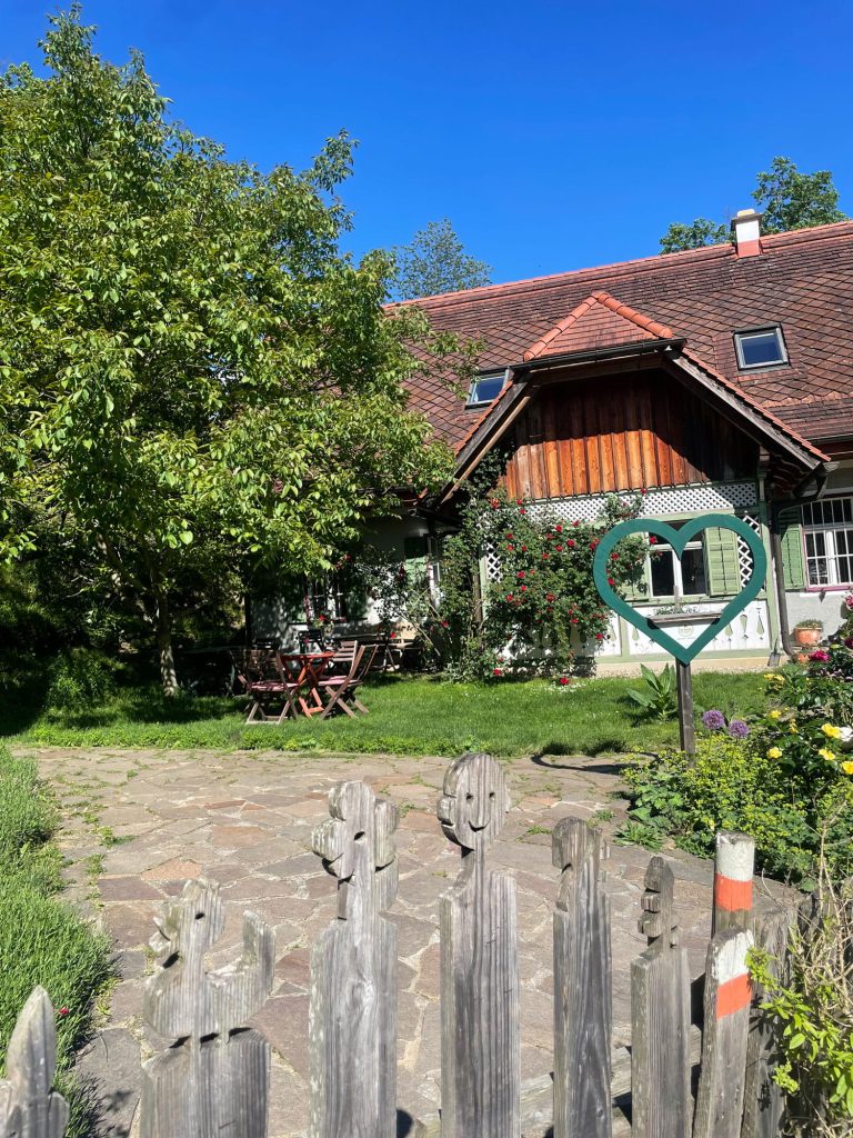 Blick auf das Haus außen mit grünem Herz im Vordergrund