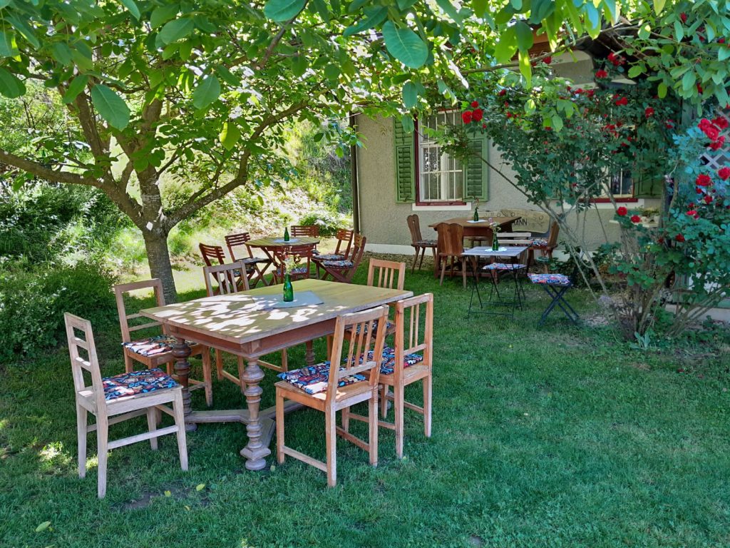 Garten mit Holztischen und Stühlen