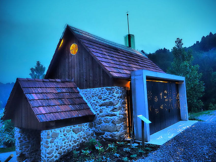 Kapelle bei Dämmerung, Licht dringt durch die Fenster nach außen