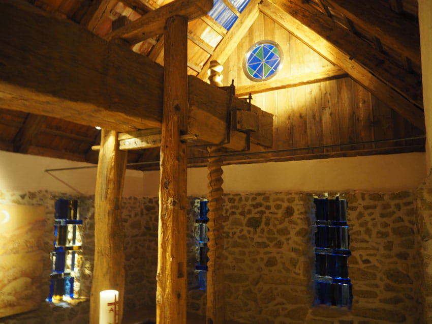 Historische Steinmühle mit Holzbalken und Kerzenlicht im Inneren