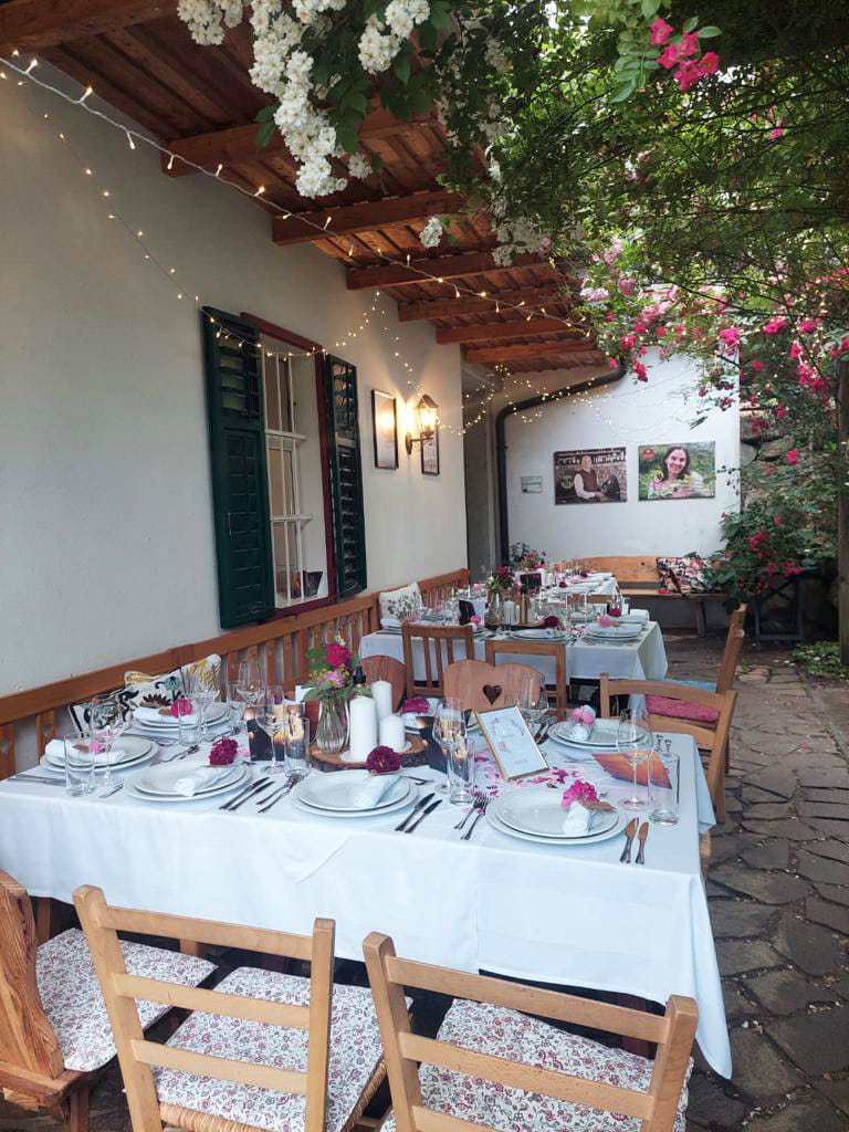 Elegante Tafeln-Dekoration im Freien mit weißen Tischdecken und Blumenschmuck.